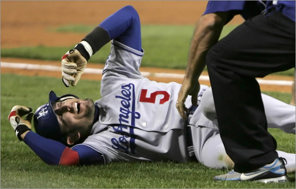 Dodgers' Nomar Garciaparra is helped by trainer Stan Conte after injuring his left knee rounding third base on a fifth inning single by Dodgers' Pablo Ozuna against the Pittsburgh Pirates in a baseball game in Pittsburgh Wednesday, Sept. 17, 2008. Garciaparra was tagged out by Pirates catcher Ryan Doumit to end the inning. Garciaparra left the game.