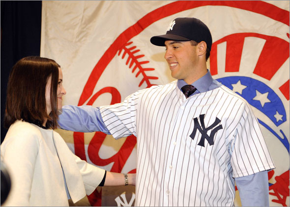New York Yankees first baseman Mark Teixeira looks at his wife Leigh at a news conference after signing as a free agent with the team at Yankee Stadium in New York, January 6, 2009.