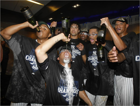 Yankees celebrate in the clubhouse after they clinched the American League East Division with a 4-2 victory over the Boston Red Sox in a baseball game at Yankee Stadium, Sunday, Sept. 27, 2009, in New York. Players include second baseman Robinson Cano, second from right, outfielder Melky Cabrera, front center, and reliever Edwar Ramirez, etc.