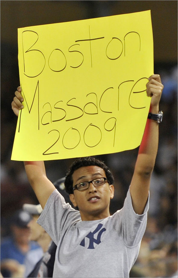 A fan in the stands holds up a sign as the Boston Red Sox play the New York Yankees in the eighth inning of their MLB American League baseball game at Yankee Stadium in New York, August 9, 2009. The Yankees beat the Red Sox and swept their four-game series to expand their hold on first place in the AL East.
