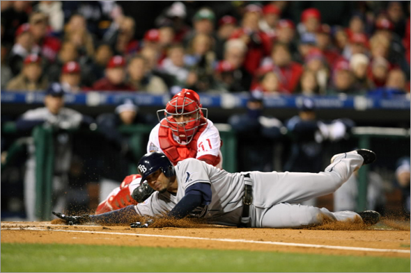 Jason Bartlett of the Tampa Bay Rays is tagged out at home plate by catcher Carlos Ruiz of the Philadelphia Phillies to end the top of the seventh inning during the continuation of game five of the 2008 MLB World Series on October 29, 2008 at Citizens Bank Park in Philadelphia, Pennsylvania.