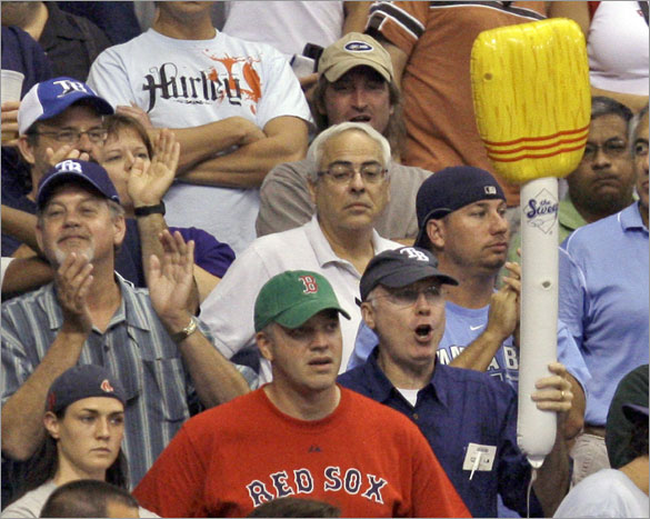 Rays fan celebrates with an inflatable broom next to a Boston Red Sox fan following the Rays 7-6 win during a baseball game Wednesday, July 2, 2008, in St. Petersburg, Fla. The Rays swept a three-game series from the Red Sox. 