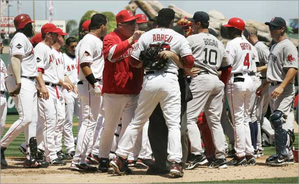Bobby Abreu is held back by the umpire and Angels manager Mike Scioscia as the benches clear after Boston Red Sox's Josh Beckett threw a high pitch that hit the backstop during the first inning of a baseball game Sunday, April 12, 2009, in Anaheim, Calif. 