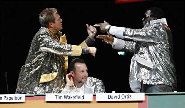 Red Sox pitcher Jonathan Papelbon, left, and designated hitter David Ortiz, right, have a mock argument above pitcher Tim Wakefield, center, during a game show spoof at the 2009 Red Sox Foundation Welcome Home Dinner