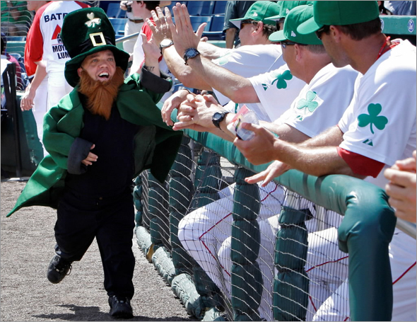 Dressed as a leprechaun, Tedi Valentine of Cape Coral, Fla. high-fives Boston Red Sox players prior to their spring training baseball game against the Minnesota Twins in Fort Myers, Fla., Tuesday March 17, 2009.