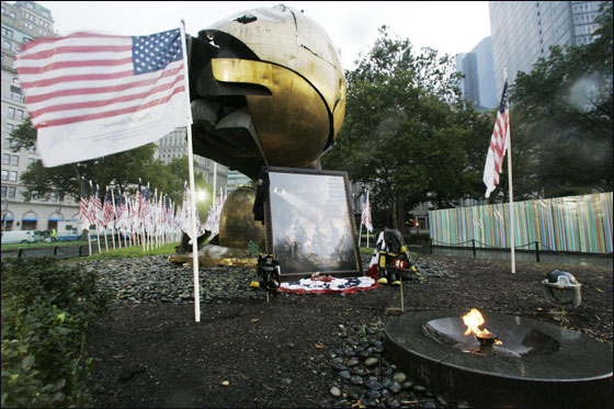 An American flag inscribed with the names of the victims of the Sept. 11 attacks flies at the 9/11 memorial field near the eternal flame and the globe saved from the World Trade Center Site on the  sixth anniversary of the terrorists attacks on the World Trade Center, Tuesday, Sept. 11, 2007, in New York.