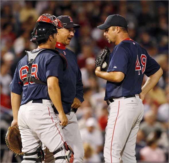 Boston Red Sox manager Terry Francona, center, talks to pitcher Tim Wakefield before taking Wakefield out of the game in the sixth inning of the Red Sox 7-1 loss to the New York Yankees in their spring training baseball game at Steinbrenner Field in Tampa, Fla., Tuesday, March 24, 2009.