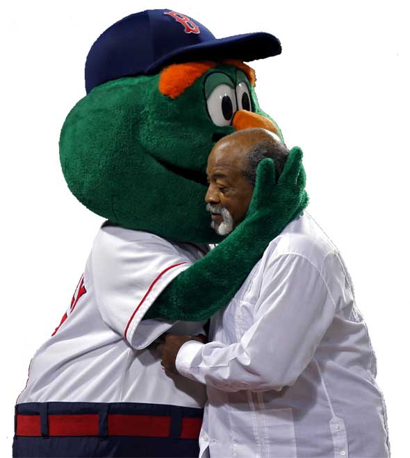 Red Sox lergend Luis Tiant gets a hug from outgoing mascot Wally the Green Monster