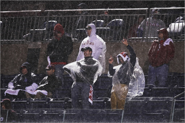 Fans watch the sixth inning in the pouring rain during Game 5 of the baseball World Series between the Philadelphia Phillies and Tampa Bay Rays in Philadelphia, Monday, Oct. 27, 2008.
