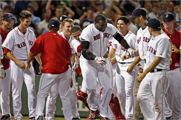 David Ortiz is mobbed at the plate after his game winning home run.The Boston Red Sox play the Chicago White Sox at Fenway Park.