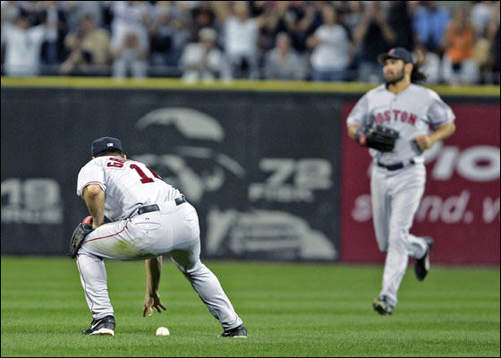 As the bleacher fans cheer in the backround, Red Sox 2B Tony Graffanino retrieves the ball he has just missed for a fifth inning error. CF Johnny Damon comes in at right.