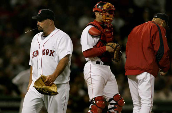 Boston Red Sox starting pitcher David Wells spits as he walks off the mound after getting pulled in the fifth inning against the Toronto Blue Jays during their baseball game at Fenway Park in Boston, Wednesday April 12, 2006. Wells gave up seven runs on ten hits in his outing. On the mound are manager Terry Francona and catcher Jason Varitek.
