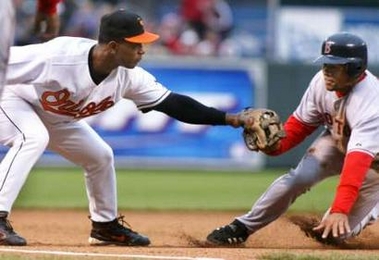 Baltimore Orioles third baseman Melvin Mora (L) tags out Boston Red Sox base runner Coco Crisp who was trying to steal third base in the third inning of their game at Camden Yards in Baltimore, Maryland April 8, 2006.