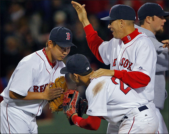 Red Sox pitcher Daisuke Matsuzaka exchanges bows with SS Julio Lugo, while at the same time getting a pat on the back from Julian Tavarez following his complete game 7-1 victory over the Detroit Tigers at Fenway Park.