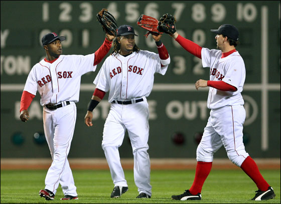 Red Sox outfielders (left to right) Willie Harris, Manny Ramirez, and Trot Nixon high five after the final out of Boston's 9-5 victory over the Yankees at Fenway Park. Globe Staff Photo/Jim Davis