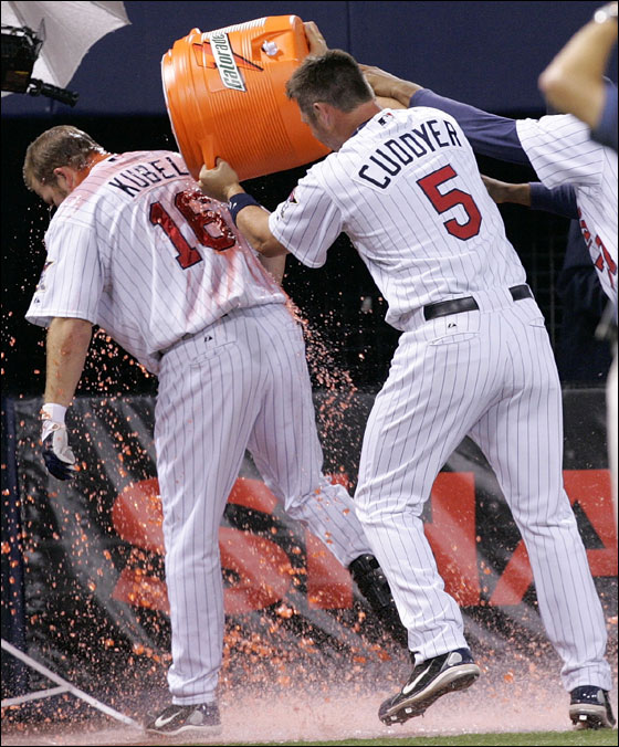 Minnesota Twins' Michael Cuddyer (5) dumps a bucket of Gatorade on teammate Jason Kubel after Kuble hit a grand slam in the 12th inning to beat the Boston Red Sox 5-2 in a baseball game in Minneapolis, Tuesday
