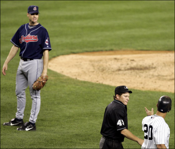 New York Yankees' Jorge Posada (20) is escorted to first base by umpire Paul Schrieber (43) as he gestures to Cleveland Indians pitcher Jason Johnson during the sixth inning Wednesday, June 14, 2006 at Yankee Stadium in New York. Posada and Johnson exchanged words after the New York catcher was hit by a pitch in the sixth, and both benches were warned. The Yankees won the game 6-1.