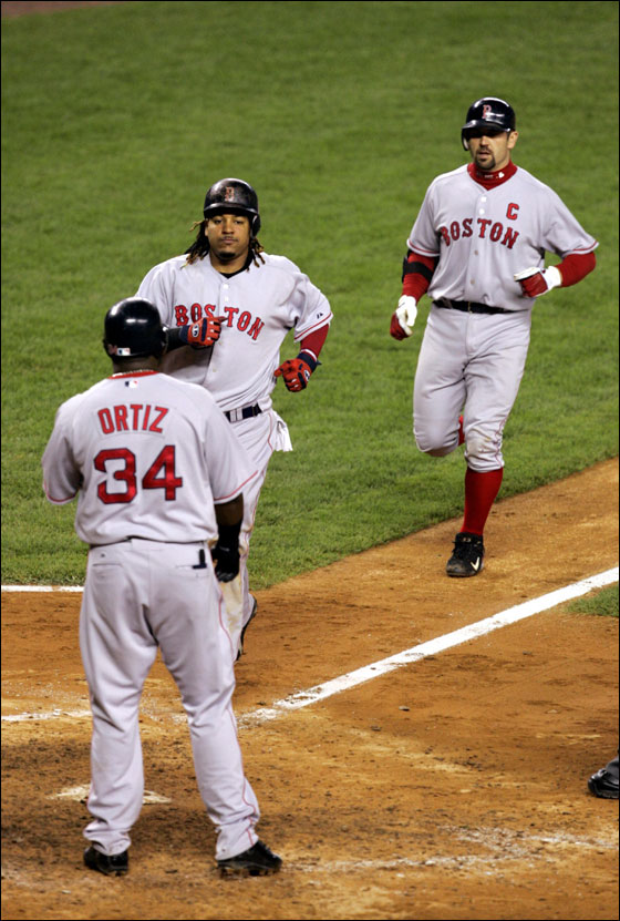 Boston Red Sox batter Jason Varitek (C) is welcomed at home plate by runners Manny Ramirez (L) and David Ortiz (R) after his three-run home run off New York Yankees relief pitcher Scott Proctor in the seventh inning of their American League game in New York's Yankee Stadium, June 8, 2006.
