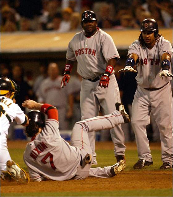 Red Sox David Ortiz, center, and Manny Ramirez, right, watch Trot Nixon slide safely past Oakland Athletic's catcher Jason Kendall, left, to score on a three-run hit by Jason Varitek in the eighth inning during a baseball game Tuesday, July 25, 2006 in Oakland, Calif. The Red Sox won 13-5.
