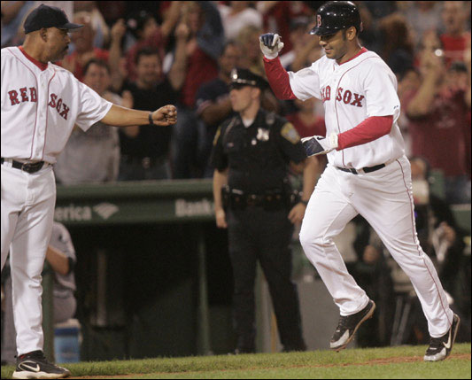 Red Sox infielder Carlos Pena rounds third base after hitting a game-winning home run during the 10th inning.  Red Sox third base coach Hale De Marlo offers congratulations. The Red Sox host the Chicago White Sox at Fenway Park in Boston, MA on Monday, September 4, 2006.