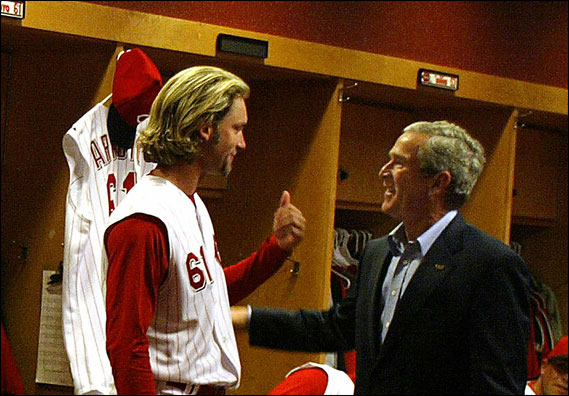 US President George W. Bush talks with right-handed Cincinnati Reds pitcher Bronson Arroyo while visiting the Reds Clubhouse before throwing out the opening pitch at the Cincinnati Reds vs. Chicago Cubs baseball game at the Great American Ball Park in Cincinnati, Ohio on April 3