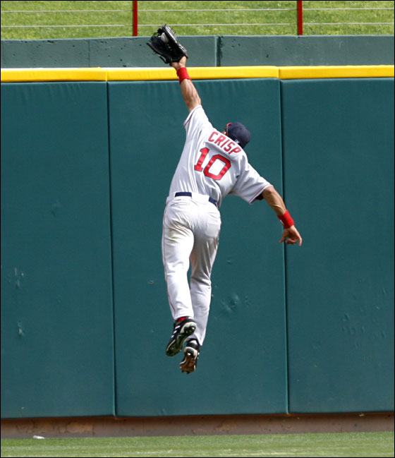 Coco Crips leaps over the wall to rob Texas Rangers Laynce Nix of an extra basses hit during 9th inning action on Monday  April 3, 2006