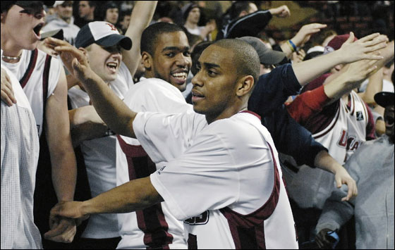 Massachusetts' Chris Lowe, center, celebrates with fans following the team's 89-87 overtime win over Alabama in an NIT basketball first-round game in Amherst, Mass. Tuesday, March 13, 2007. Lowe hit a shot in the final seconds to win the game. Looking on is teammate Brandon Thomas, center.