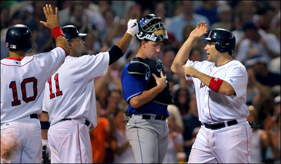 Red Sox catcher Doug Mirabelli makes his Kansas City counterpart John Buck a sad lookig backstop as he crosses the plate to high fives from Coco Crisp and Alex Gonzalez after his game tying seventh inning three run homer