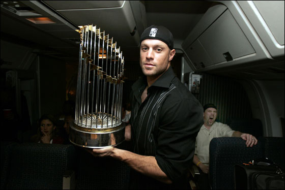 10.28.04: Sox Gabe Kapler holds the World championship trophy on a flight  from St. Louis where the Red Sox won the World Series. In the background Trot Nixon yawns.