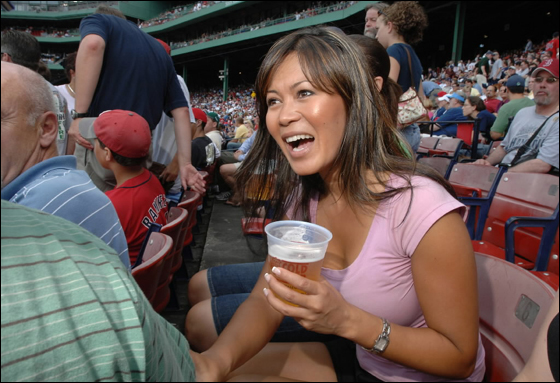 Hazel Mae, host of SportsDesk and Red Sox Rewind, both on NESN, talks shop with her neighbors in the bleachers at Fenway during the Monday, June 26, game against the Phillies.