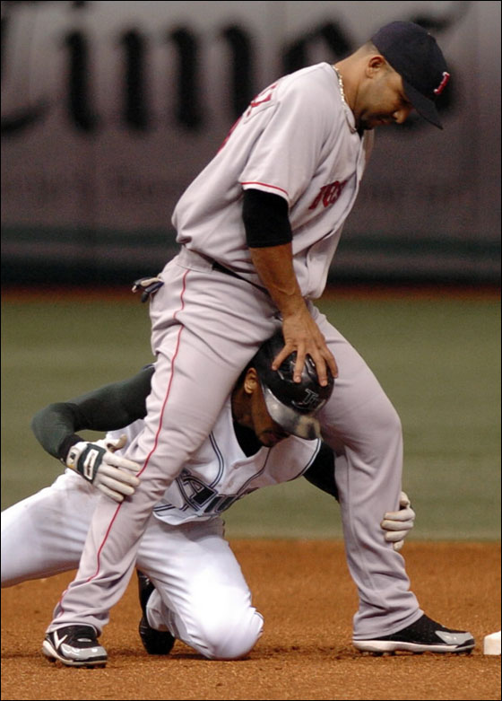 Red Sox shortstop Alex Gonzalez extricates Tampa Bay Devil Rays' Julio Lugo from his legs after forcing Lugo out at second base on a fielder's choice hit by Tampa Bay batter Carl Crawford during the fifth inning of a baseball game Tuesday, July 4, 2006, at Tropicana Field in St. Petersburg, Fla.