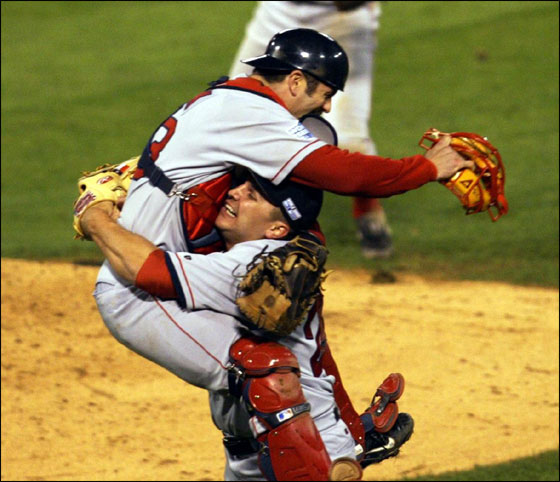 Red Sox's catcher Jason Varitek jumps into the arms of pitcher Keith Foulke after beating the St. Louis Cardinals 3-0 to win the World Series Wednesday, Oct. 27, 2004, in St. Louis. Celebrating in the background is teammate Bill Mueller.