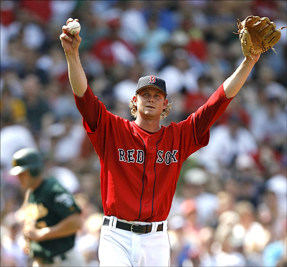 Red Sox pitcher Kyle Snyder stretches while walking towards first after walking Oakland Athletics' Marco Scutaro with the bases loaded to force in Bobby Crosby, rear, for the first run of a five run fifth inning in major league baseball at Fenway Park in Boston Sunday, July 16, 2006.