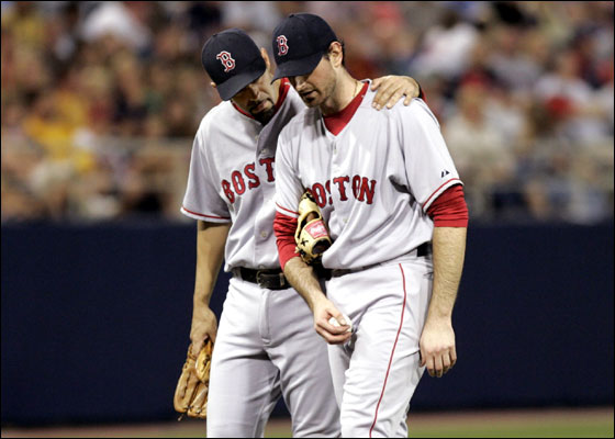 Red Sox starting pitcher Matt Clement (R) is consoled on the mound by teammate third baseman Mike Lowell before he is taken out of the game during the fifth inning of the American League baseball game against the Minnesota Twins at the Metrodome in Minneapolis June 14, 2006.