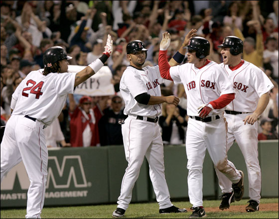 Manny Ramirez reaches out to congratulate  Kevin Youkilis, Alex Gonzalez and Mark Loretta in the 6th inning after they all scored on David Ortiz's double