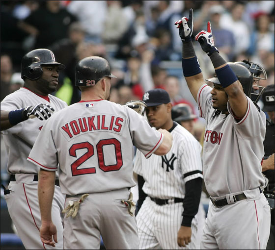 Red Sox batter Manny Ramirez is welcomed at the plate by runners David Ortiz and Kevin Youkilis after hitting a three-run home run off New York Yankees starting pitcher Mike Mussina in the first inning of their American League baseball game in New York May 22, 2007.
