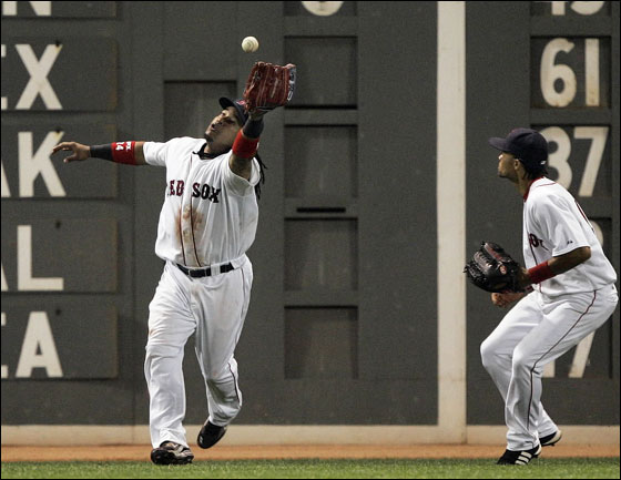 Red Sox centerfielder Coco Crisp, right, watches as left fielder Manny Ramirez plays a double off the wall by Kansas City Royals' Tony Pena, scoring Alex Gordon in the seventh inning of a baseball game Tuesday, July 17, 2007, in Boston.