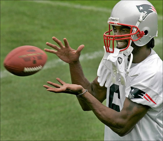 Randy Moss catches a Tom Brady pass while playing catch along the sidelines during today's mini camp practice.