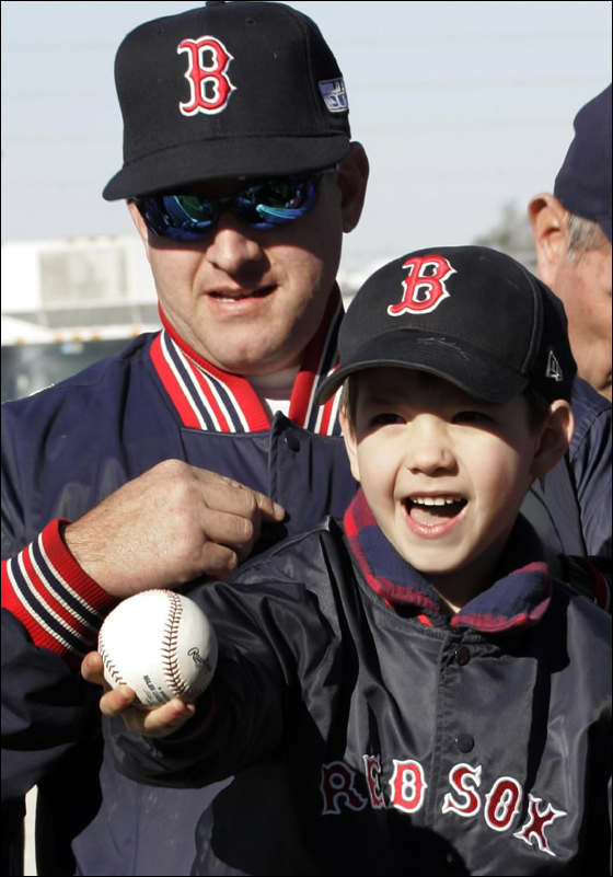 Boston Red Sox fan Robert Gravel of Ocala, Fla., left, and his son Robbie, 5,right, wait to get autographs from players at baseball spring training camp in Fort Myers, Fla, Monday, Feb. 19, 2007.