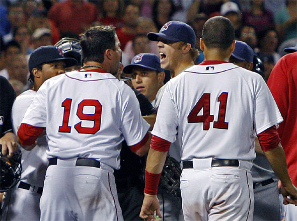 Josh Beckett and  Indians pitcher Jensen Lewis scream at each other at center right restrained after a tight 8th inning pitch.The Boston Red Sox take on the Cleveland Indians at Fenway Park.