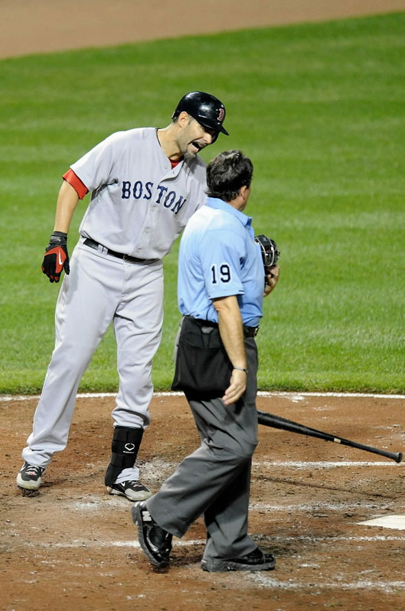 Mike Lowell #25 of the Boston  Red  Sox  argues with home plate umpire Ed Rapuano after being called out on strikes against the Baltimore Orioles at Camden Yards on August 31, 2010 in Baltimore, Maryland.