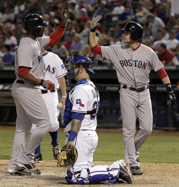 Texas Rangers catcher Napoli kneels by home plate as Boston Red Sox's Crawford, left, and Lowrie, right, celebrate Crawford's two-run home run that also scored Lowrie in the seventh inning of a baseball game on Wednesday, Aug. 24, 2011, in Arlington, Texas.