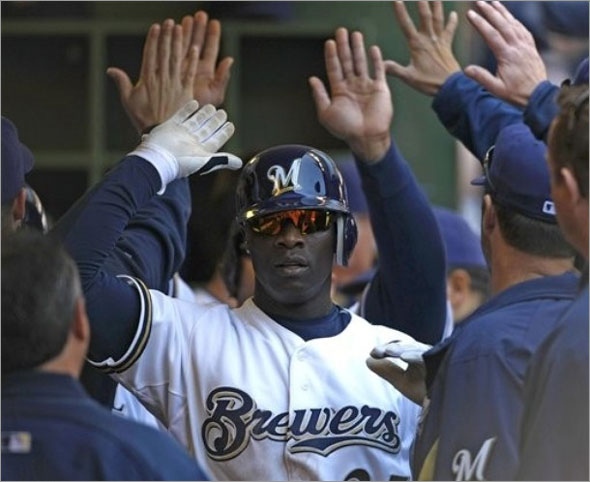 Milwaukee Brewers' Mike Cameron high fives teammates after his two-run home run against the Cincinnati Reds during the third inning of a baseball game Sunday, May 31, 2009, in Milwaukee