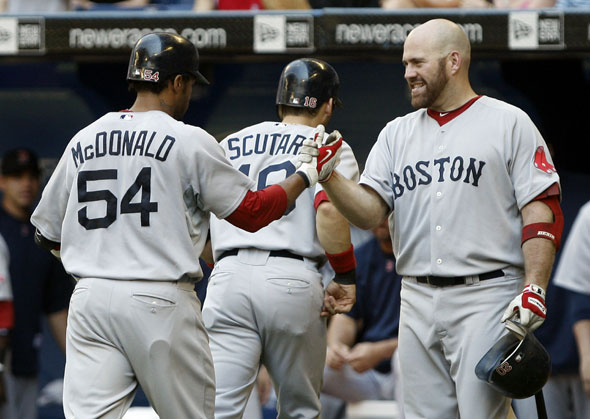 Darnell McDonald, Marco Scutaro and Kevin Youkilis of the Boston Red Sox celebrate Darnell McDonald's two-run home run during the game against the Toronto Blue Jays at the Rogers Centre on July 11, 2010 in Toronto, Ontario, Canada.