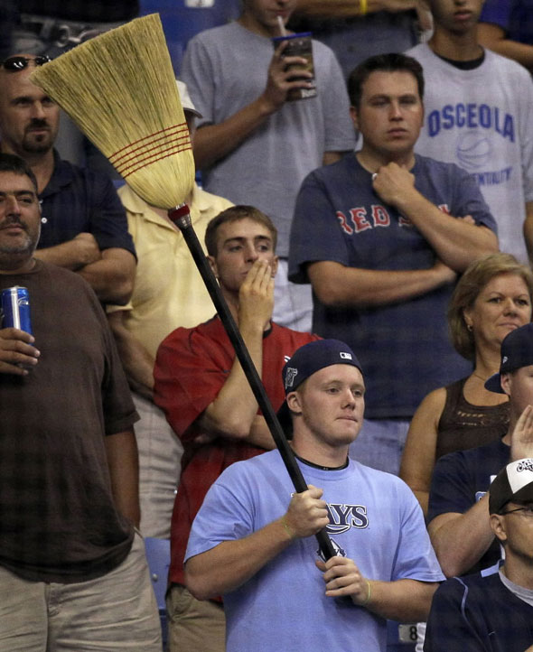 A Tampa Bay Rays fan holds a broom after the Rays defeated the Boston Red Sox 6-4 to sweep a three-game baseball series Wednesday, July 7, 2010, in St. Petersburg, Fla.