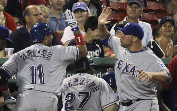 Texas Rangers' Bengie Molina, left, is congratulated by starting pitcher Colby Lewis, right, after Molina's grand slam off Boston Red Sox pitcher Fernando Cabrera during the fifth inning of a baseball game in Boston, Friday, July 16, 2010.