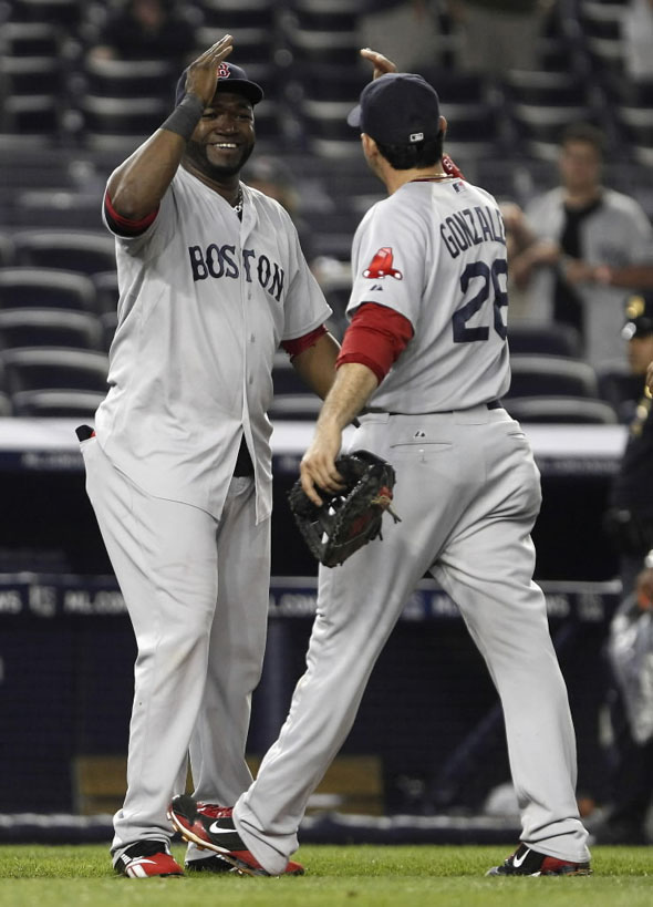 David Ortiz (L) slaps hands with teammate Adrian Gonzalez (R) at the conclusion of the ninth inning of American League MLB baseball action against the New York Yankees at Yankee Stadium in New York June 9, 2011.