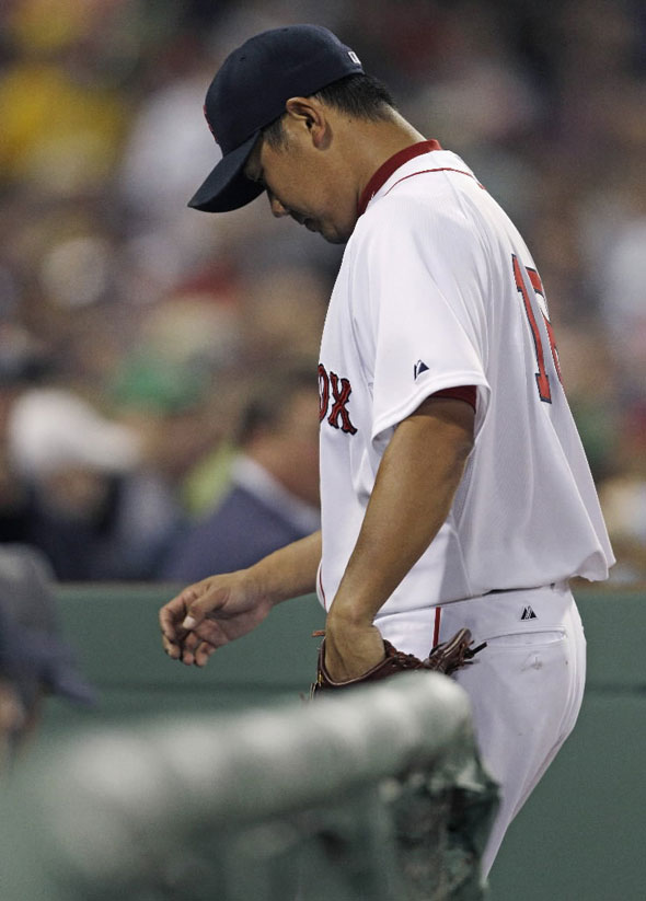 Daisuke Matsuzaka steps into the dugout after being removed from the baseball game against the Tampa Bay Rays during the third inning in Boston, Monday, April 11, 2011. Matsuzaka allowed seven earned runs on eight hits in his outing. 