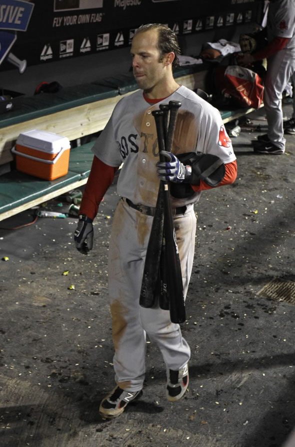 Dustin Pedroia collects bats in the dugout after the Red Sox lost to the Cleveland Indians 3-1 in a baseball game Tuesday, April 5, 2011, in Cleveland.