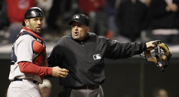 Home plate umpire Dale Scott, right, tells Boston Red Sox catcher Jason Varitek that Cleveland Indians' Travis Buck is safe at home plate in the sixth inning in a baseball game, Wednesday, April 6, 2011, in Cleveland. Buck scored on a fielders choice for Michael Brantley. The Indians won 8-4.